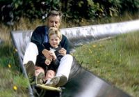 Vater und Sohn auf einer Rodel in der Rodelbahn