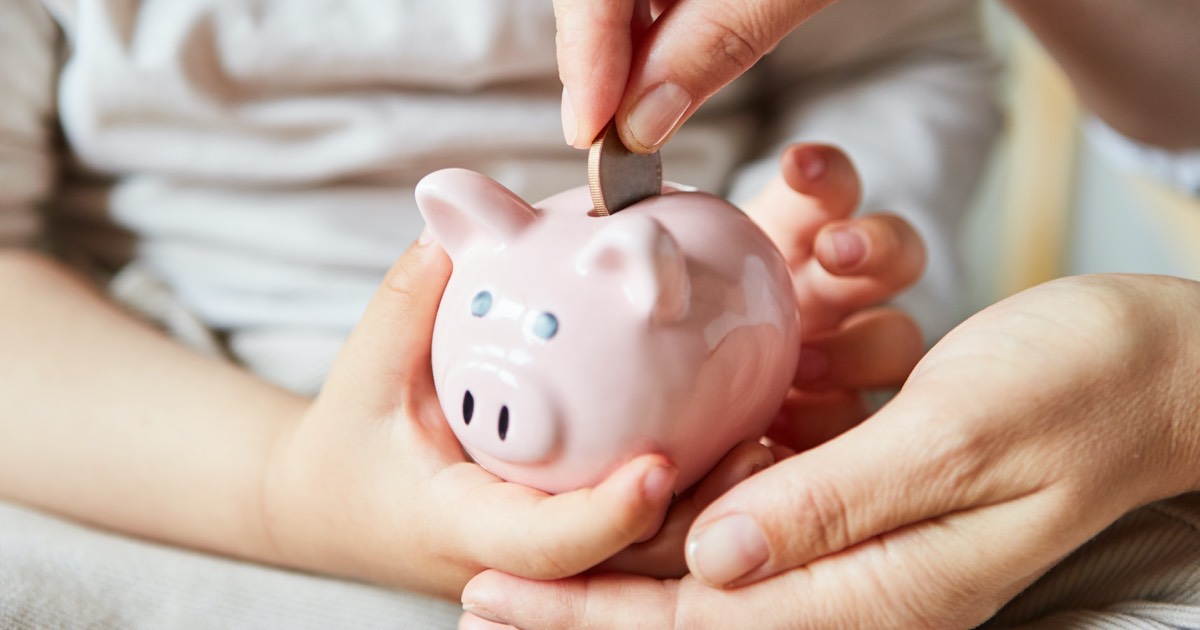 Mädchen spart ihr Taschengeld mit einer Spardose