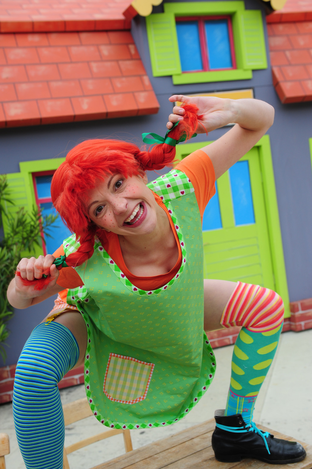 Schauspielerin verkleidet als Pippi Langstrumpf mit roten Zöpfen